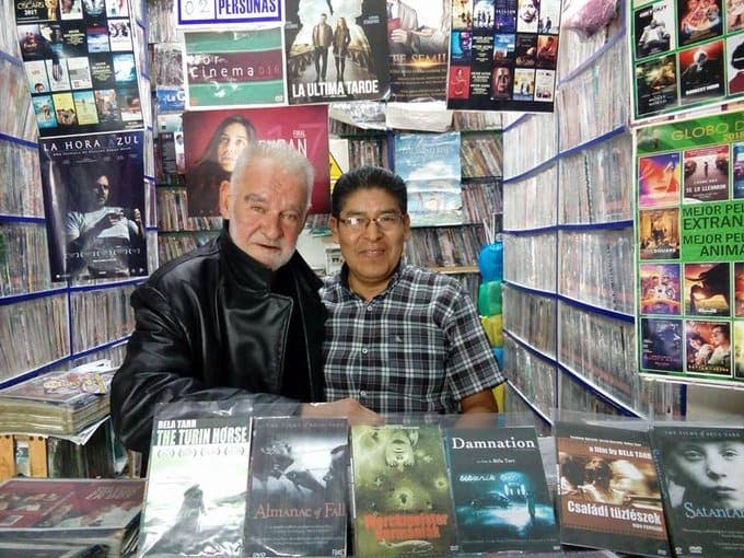 Béla Tarr posa junto a sus películas pirata en el rincón cinéfilo más exquisito de Lima, Perú