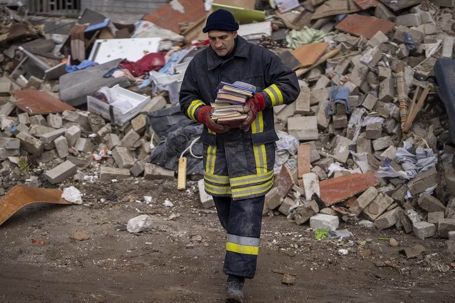 Bombero rescata libros de edificio bombardeado en Ucrania, 23 de abril de 2022 (Emilio Morenatti)